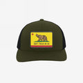 California Gadsden Flag Trucker Hat with an olive front and black mesh back. Features a leatherette patch with a bear and the phrase “DON’T TREAD ON US,” symbolizing defiance and unity.