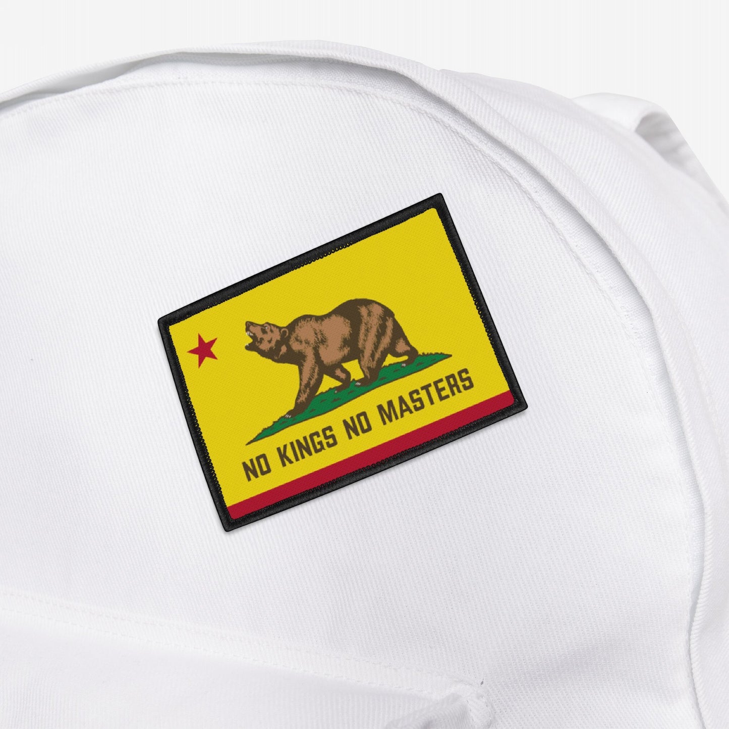 The California Flag No Kings Patch features a grizzly on grass with a red star, subtly styled with NO KINGS NO MASTERS text, symbolizing rebellion. Perfect for personalizing backpacks or apparel.