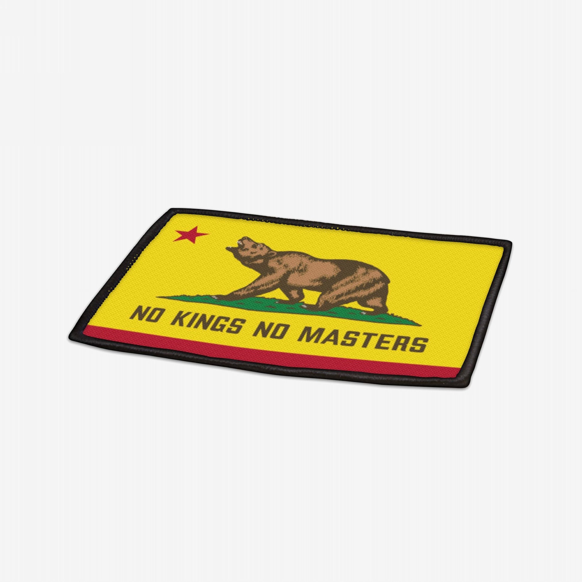 California Flag No Kings Patch features a brown bear on grass with “NO KINGS NO MASTERS” text, symbolizing rebellion. Red star in corner, black-edged polyester with iron-on backing. Size: 3.5 x 2.5.