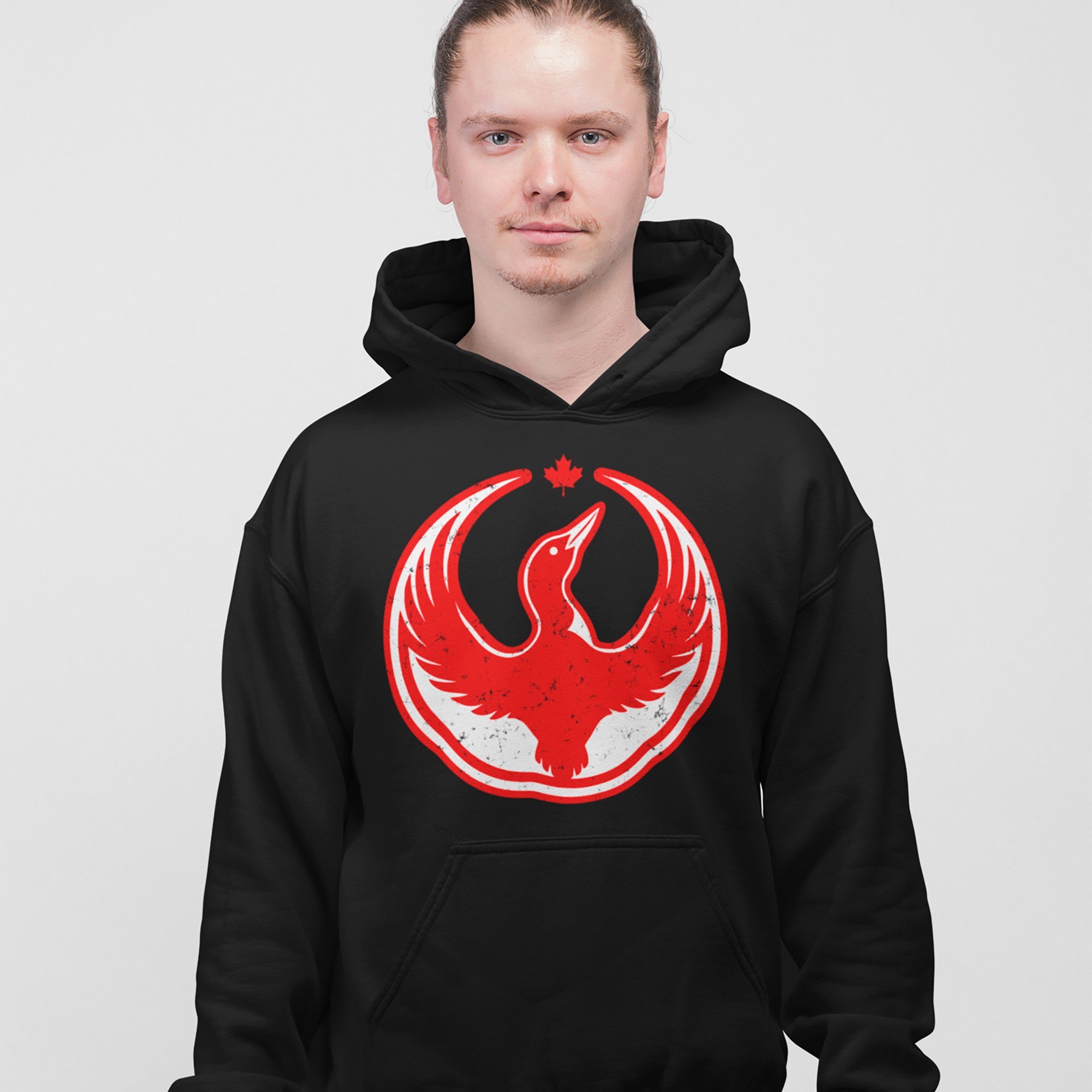Canada Rebel Alliance Hoodie featuring a stylized red-and-white phoenix graphic and maple leaf emblem, worn by a person with light skin and blue eyes. Ideal for expressing anti-fascist, pro-equality values.