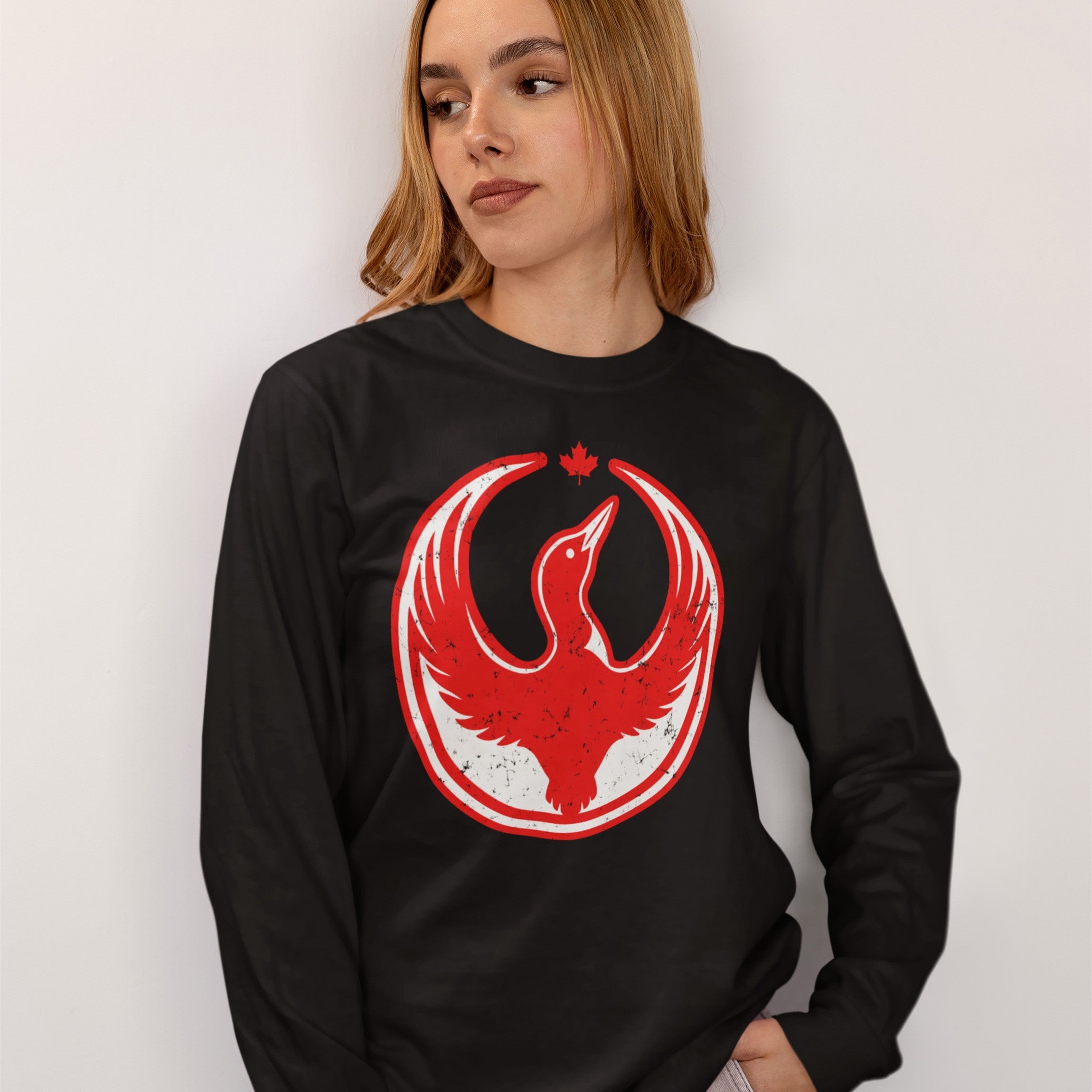 Young woman wearing a Canada Rebel Alliance T-shirt with a distressed red-and-white graphic of a stylized bird and maple leaf, symbolizing anti-fascist protest and community support.
