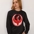Young woman wearing a Canada Rebel Alliance T-shirt with a distressed red-and-white graphic of a stylized bird and maple leaf, symbolizing anti-fascist protest and community support.