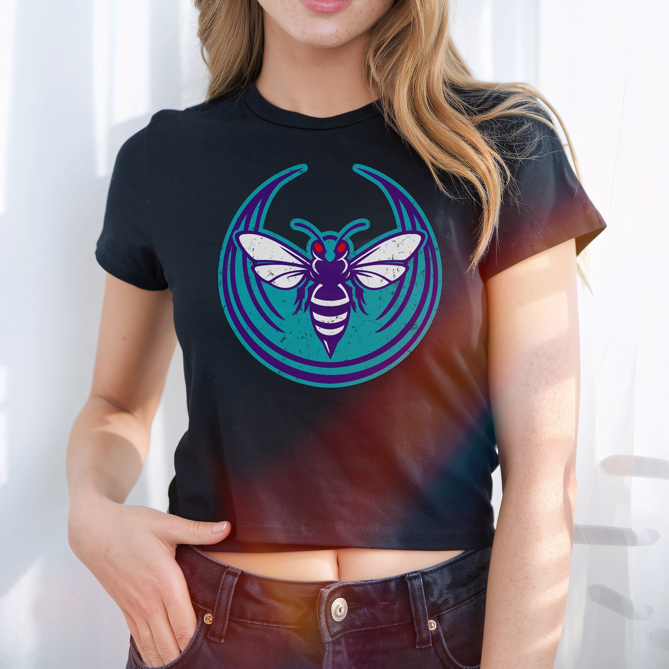 Charlotte Rebel Alliance Women's Baby Tee featuring a vibrant hornet logo in purples and teal on black. The cropped T-shirt embodies city pride and protest spirit, perfect for advocates of equality.