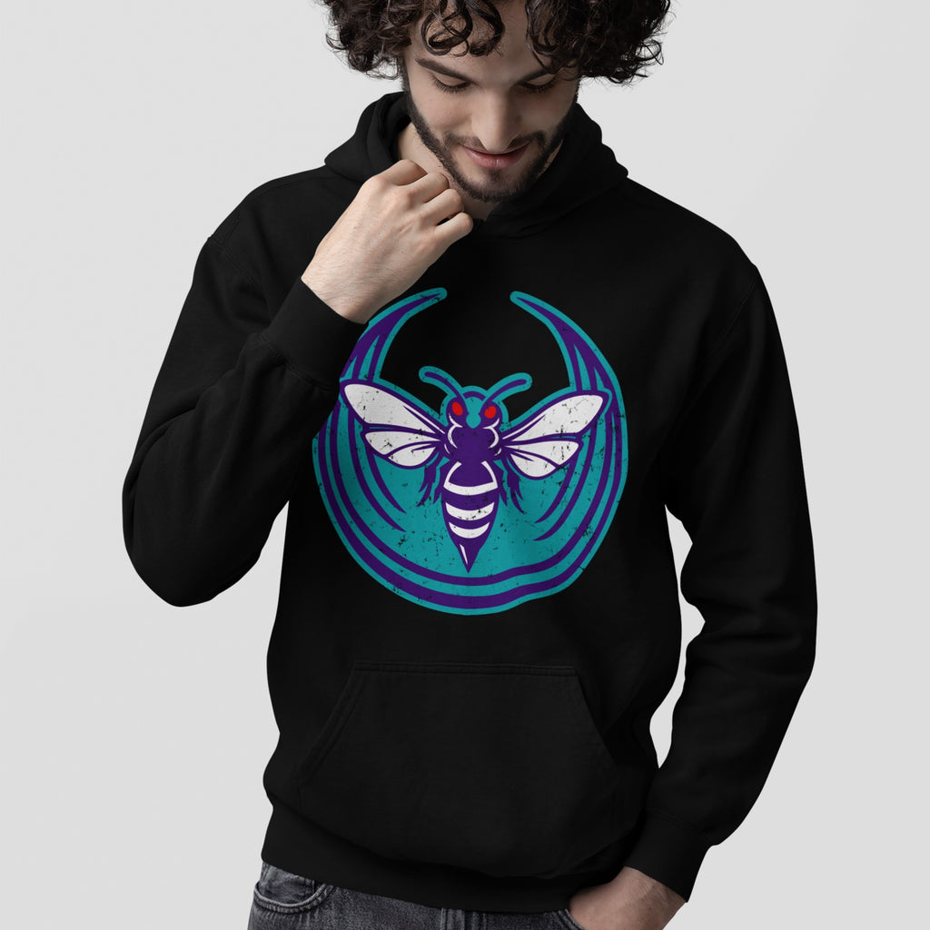 Person wearing Charlotte Rebel Alliance Hoodie featuring a purple, white, and teal hornet emblem, embodying protest spirit and anti-fascist values, reflecting a bold statement for those who resist conformity.