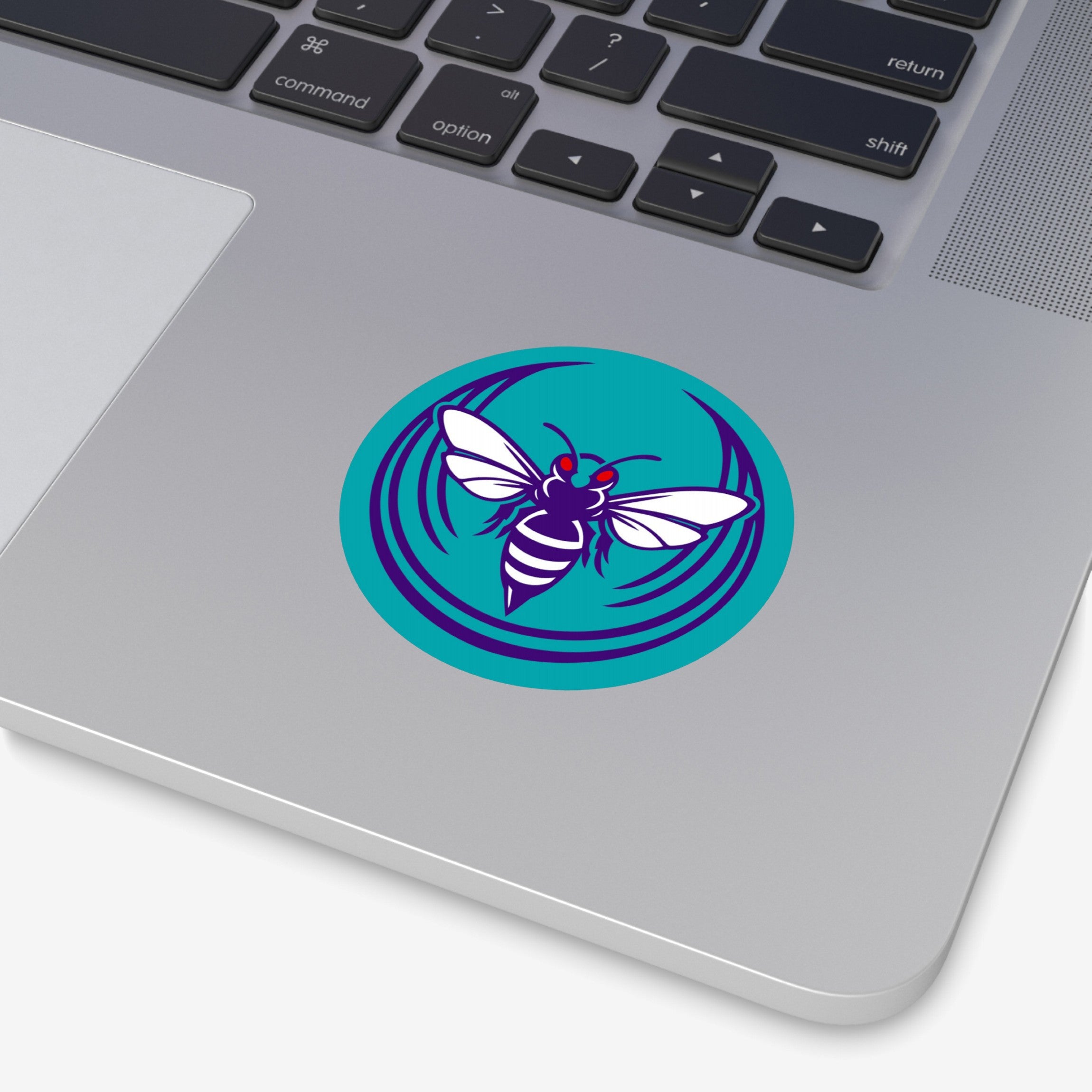 The Charlotte Rebel Alliance Sticker, featuring a stylized bee with a purple body and red eyes, adorns the laptop's palm-rest, embodying anti-fascist and pro-equality values.