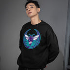 Young man in a black crewneck sweatshirt featuring the Charlotte Rebel Alliance design with a stylized bee graphic in purple, white, and teal, embodying a bold, anti-fascist statement.
