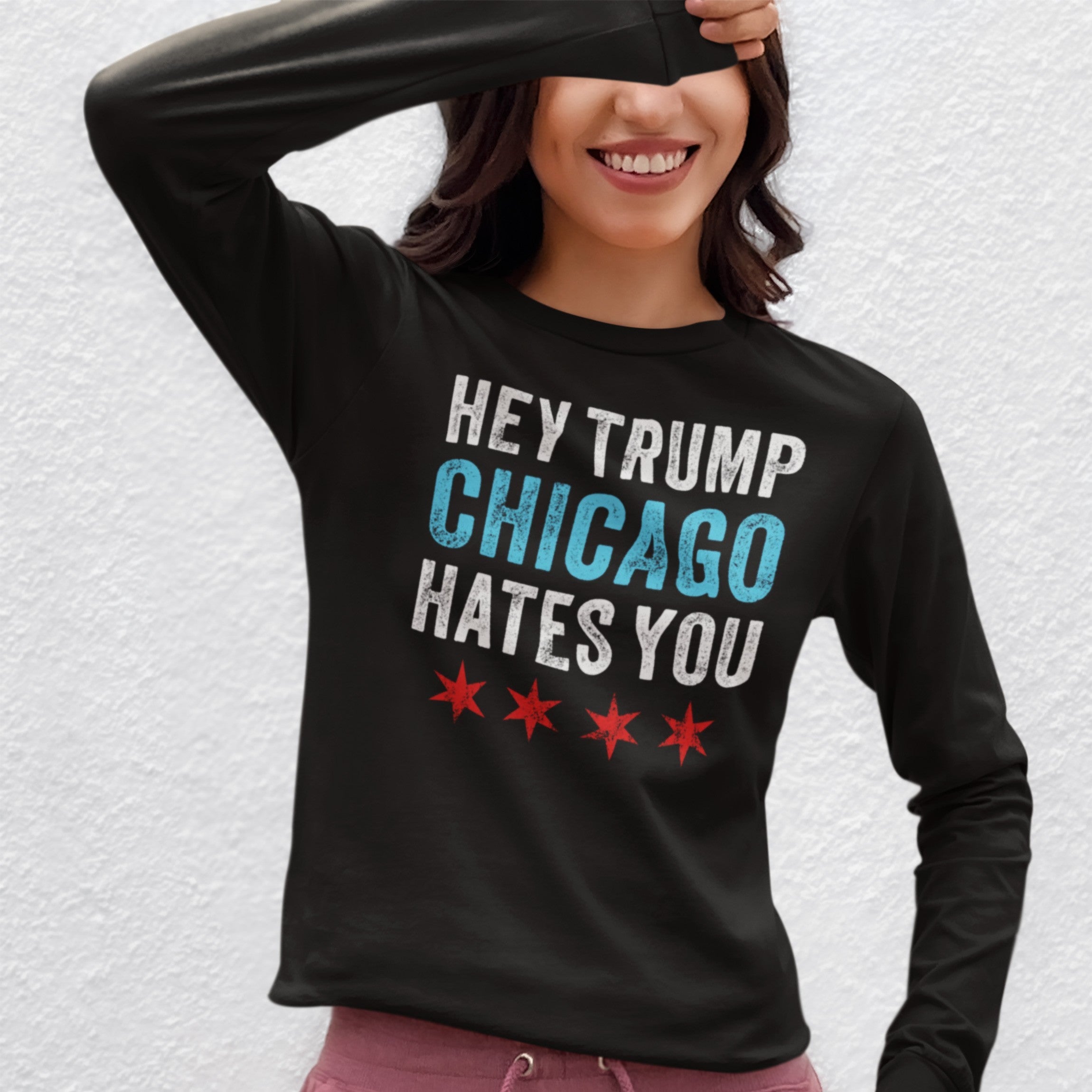 Chicago Hates Trump T-shirt features bold, distressed white and blue text with Chicago stars, worn by a smiling person, embodying an anti-MAGA message against fascism and supporting equality.