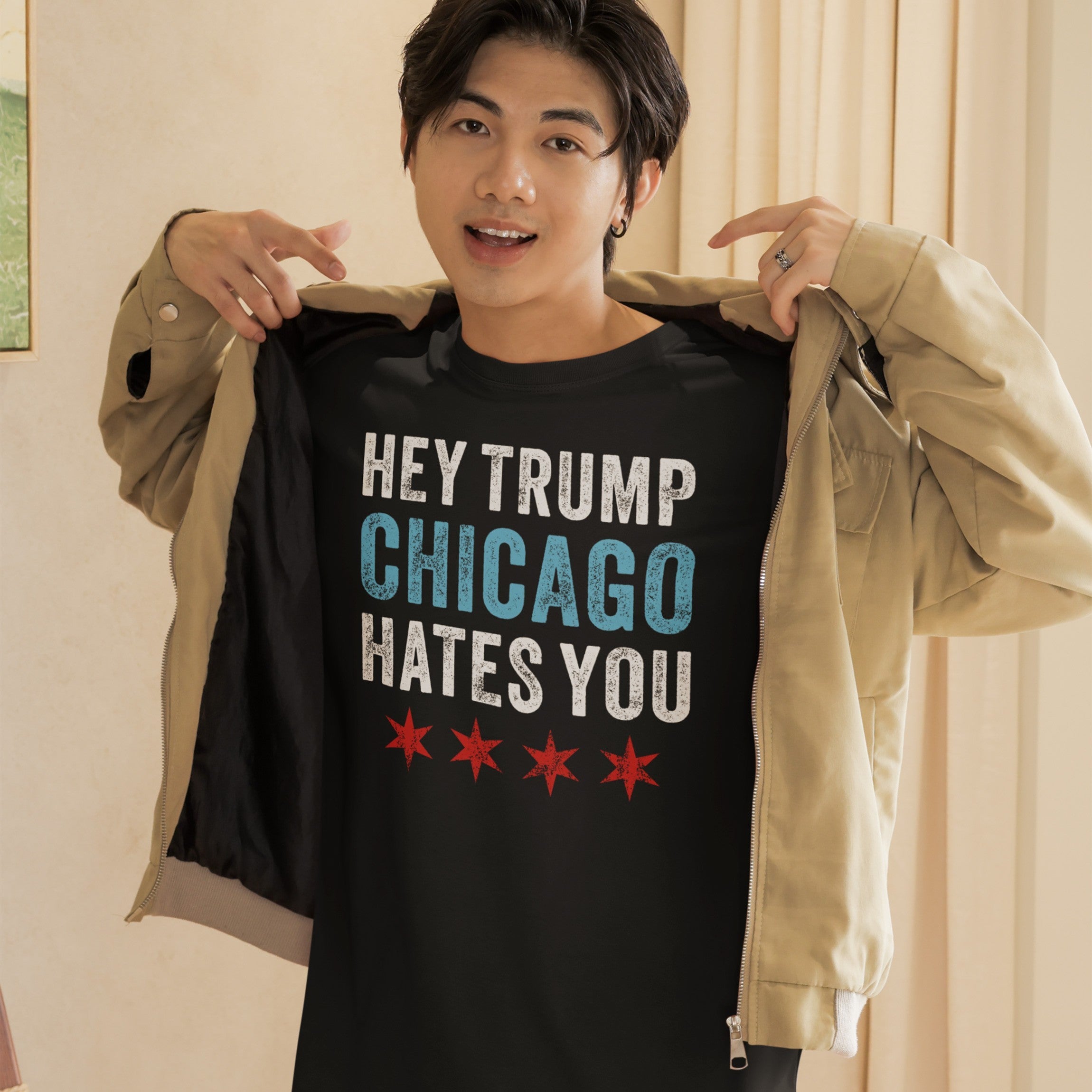 Young male displaying the Chicago Hates Trump T-shirt, featuring HEY TRUMP CHICAGO HATES YOU with distressed lettering and red stars, promoting anti-fascism and local pride. A bold statement piece.