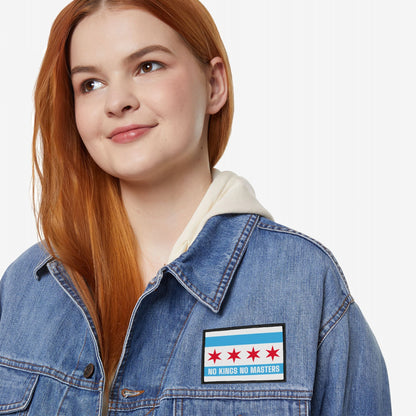 A young woman models the Chicago Flag No Kings Patch, featuring five red stars and NO KINGS NO MASTERS slogan on a denim jacket, embodying an anti-authoritarian message.