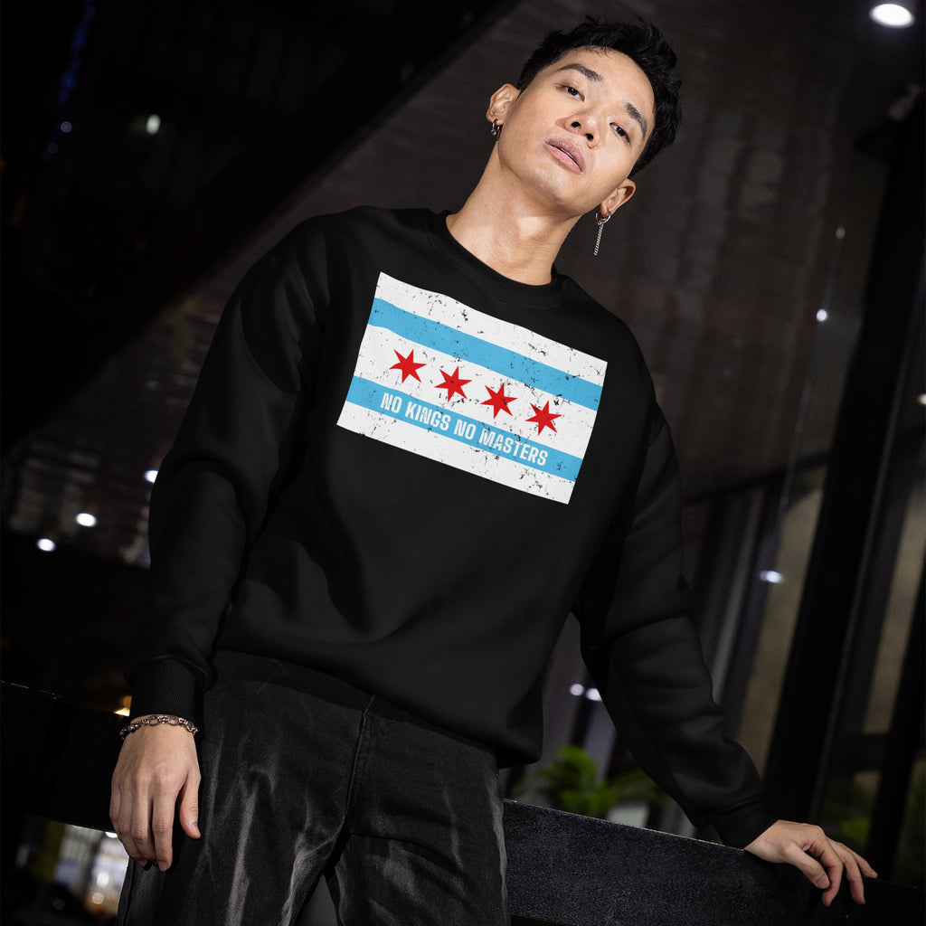 Young man in an urban night setting wears the Chicago No Kings Flag Shirt, featuring Chicago's flag and NO KINGS NO MASTERS slogan, embodying defiance and advocacy for freedom and equality.