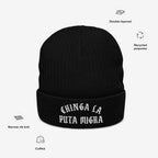 Chinga La Migra Hat: Black cuffed knit beanie with 'Chinga La Puta Migra' in white Old English embroidery, symbolizing defiance against ICE, made from recycled polyester in narrow-rib stitch.