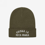 Olive-green rib-knit beanie titled Chinga La Migra Hat, features bold white Old English embroidery stating “CHINGA LA PUTA MIGRA” on the front cuff, symbolizing defiance against ICE/CBP.
