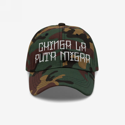 Camouflage-print baseball cap with hand-stitched embroidery reading Chinga La Migra, boldly confronting immigration enforcement. The cap is a statement piece against oppression, available in various styles.