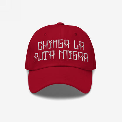 Red baseball cap with bold, white embroidered text Chinga La Puta Migra. The Chinga La Migra Hat is a defiant stance against immigration authorities, embodying resistance and solidarity against oppression.