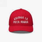 Chinga La Migra Hat with bold Old English-style white embroidery, Chinga La Puta Migra, on a red trucker cap, embodying anti-fascist sentiment and immigrant rights advocacy.