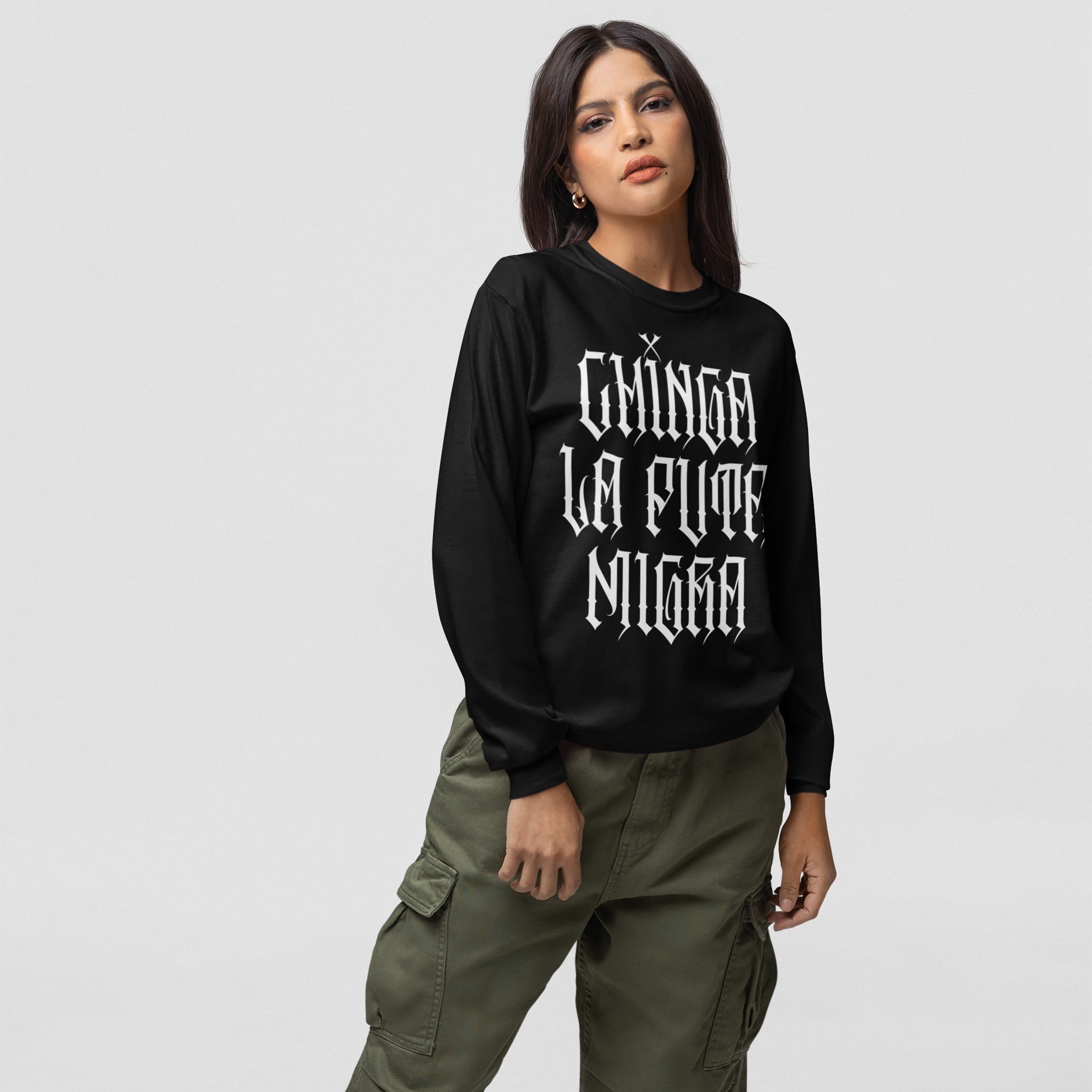 Model wearing the Chinga La Migra T-shirt with bold Chinga La Puta Migra text in gothic font, paired with olive cargo pants, embodying resistance and conviction through fashion.