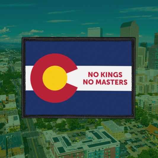 Colorado Flag No Kings Patch featuring the state flag's iconic C and bold red text, NO KINGS NO MASTERS, set against a cityscape backdrop, promoting self-governance and individuality.