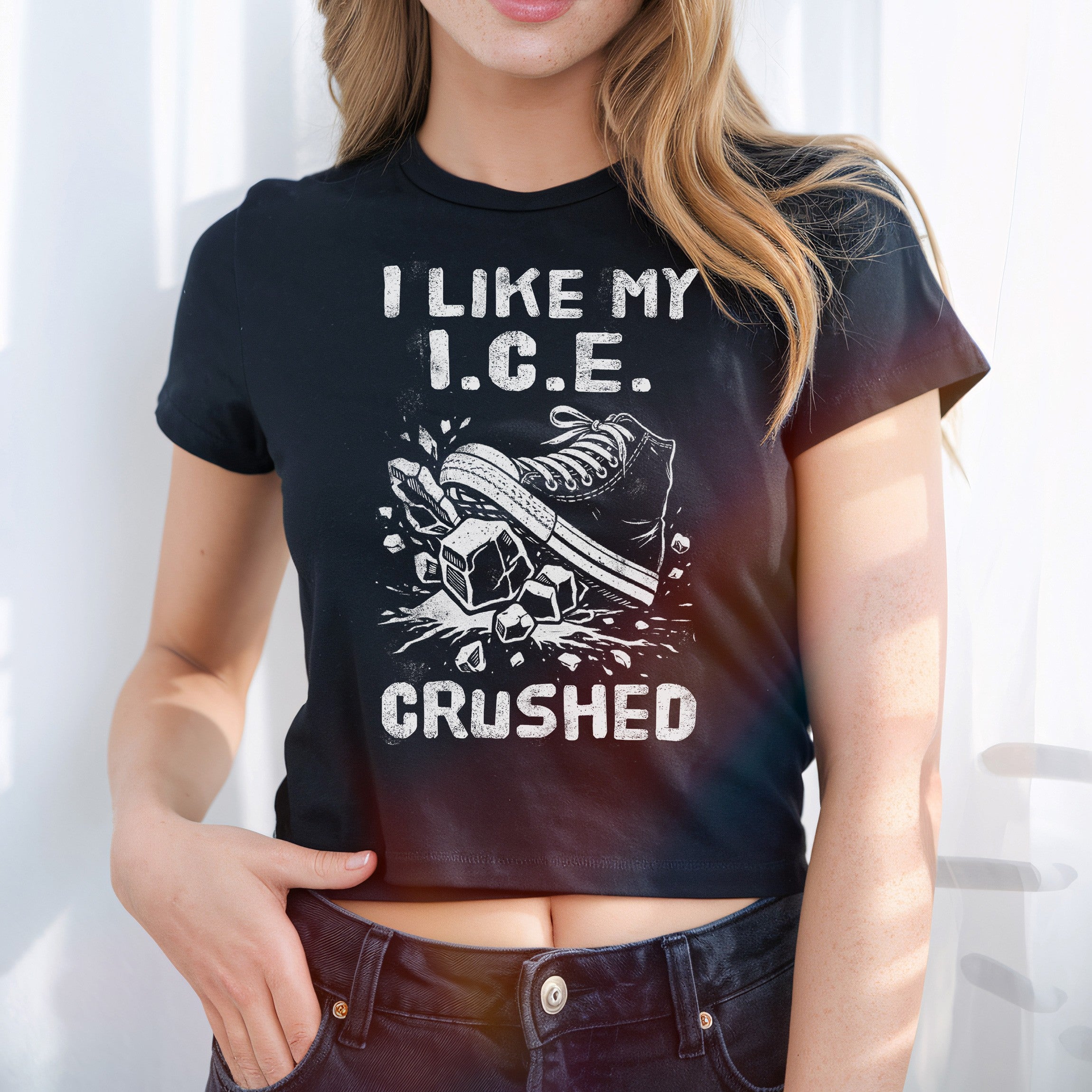 Person wearing the Crushed ICE Women's Baby Tee with bold graphic of a sneaker crushing ice cubes, expressing a strong protest message against ICE, styled in a retro Y2K cropped fit.