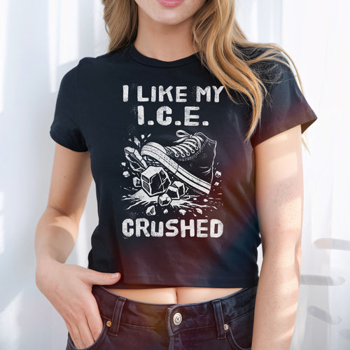 Person wearing the Crushed ICE Women's Baby Tee with bold graphic of a sneaker crushing ice cubes, expressing a strong protest message against ICE, styled in a retro Y2K cropped fit.