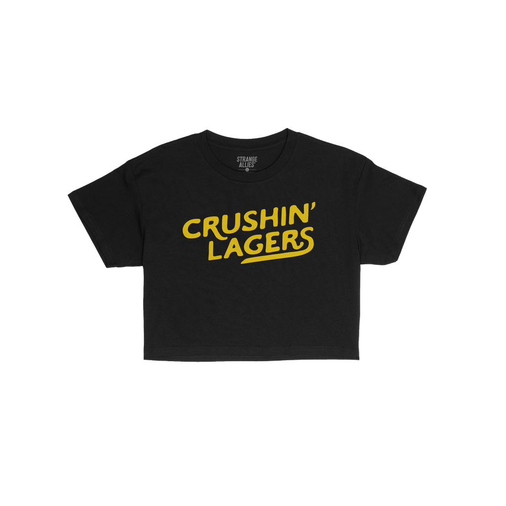 Crushin' Lagers Women's Baby Tee featuring bold yellow slogan on a plain black short-sleeve design, embodying retro varsity v