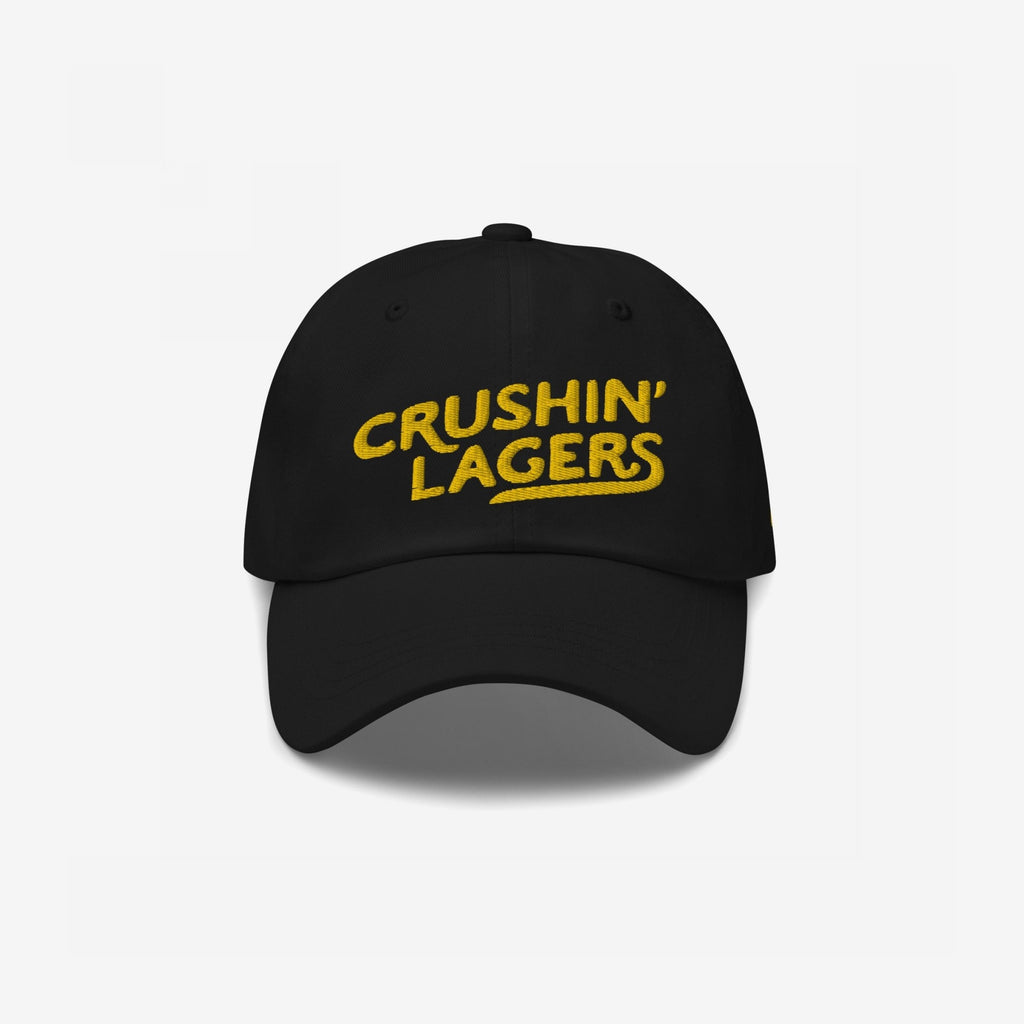 Crushin' Lagers Hat: Black unstructured baseball cap with CRUSHIN’ LAGERS in bold yellow, embracing lager culture for beer enthusiasts. Perfect for breweries or casual outings, blending style with a love for good beer.