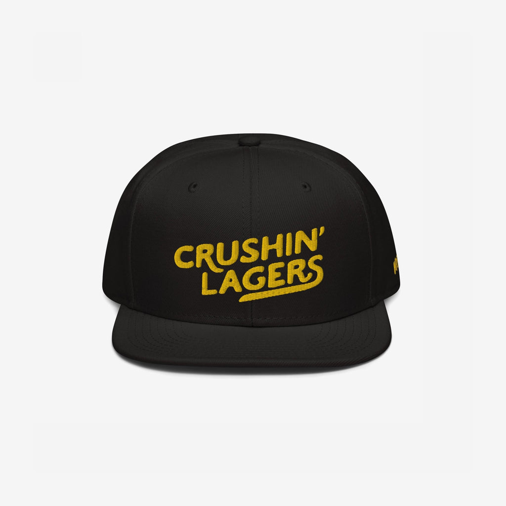 Crushin' Lagers Hat: This black snapback features a bold yellow CRUSHIN' LAGERS embroidery, celebrating lager enthusiasts with a retro twist. Perfect for casual outings and brewery visits, embodying good vibes and inclusivity.