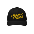 Crushin' Lagers Hat features a black mesh-back trucker design with bold yellow embroidery, curved visor, and snapback closure