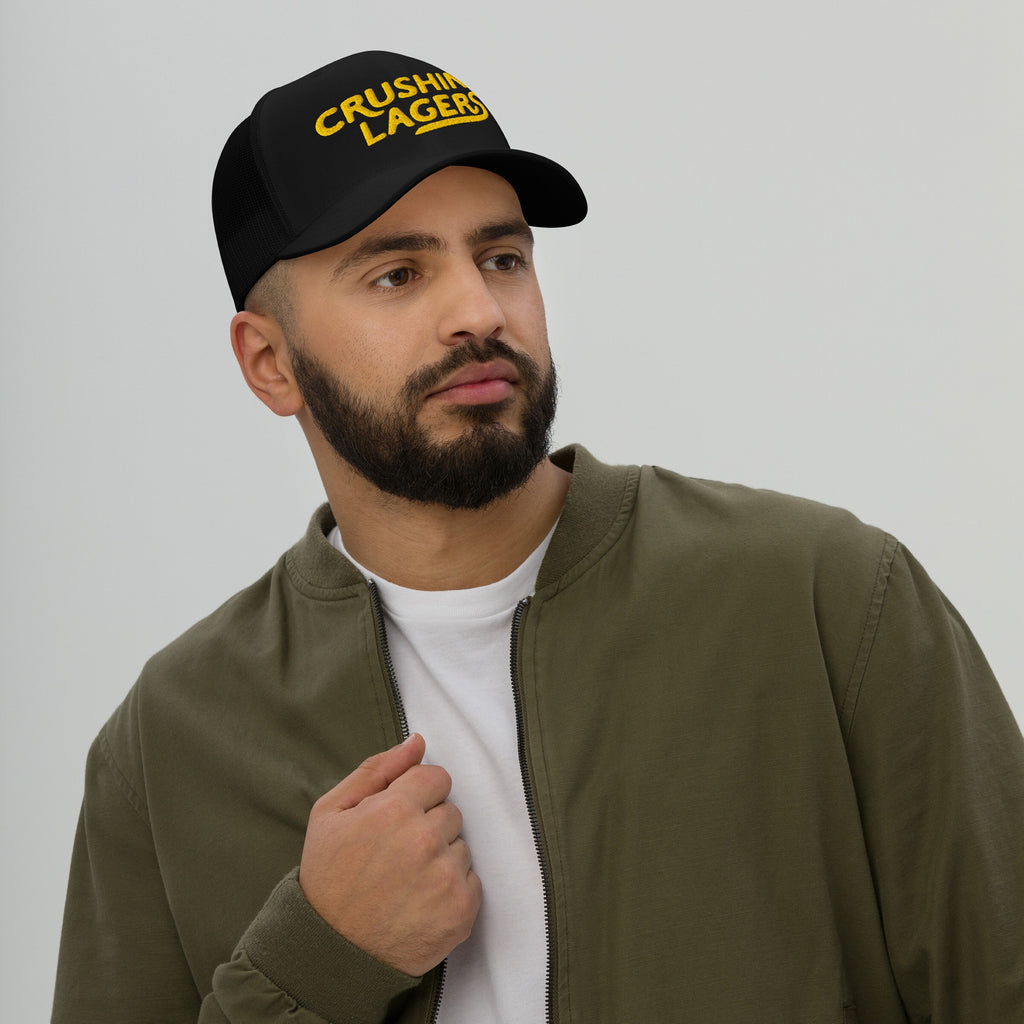 Bearded man wearing the Crushin' Lagers Hat, a black trucker cap with CRUSHING LAGERS in yellow, embodying laid-back vibes, ideal for lager enthusiasts and casual outings.