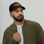 Bearded man wearing the Crushin' Lagers Hat, a black trucker cap with CRUSHING LAGERS in yellow, embodying laid-back vibes, ideal for lager enthusiasts and casual outings.