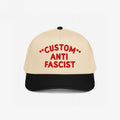 Two-tone cap with a beige crown and black bill, featuring bold red embroidery, CUSTOM ANTI FASCIST, showcasing the Custom Anti-Fascist 5-Panel Hat's structured design, adjustable fit, and activism statement.