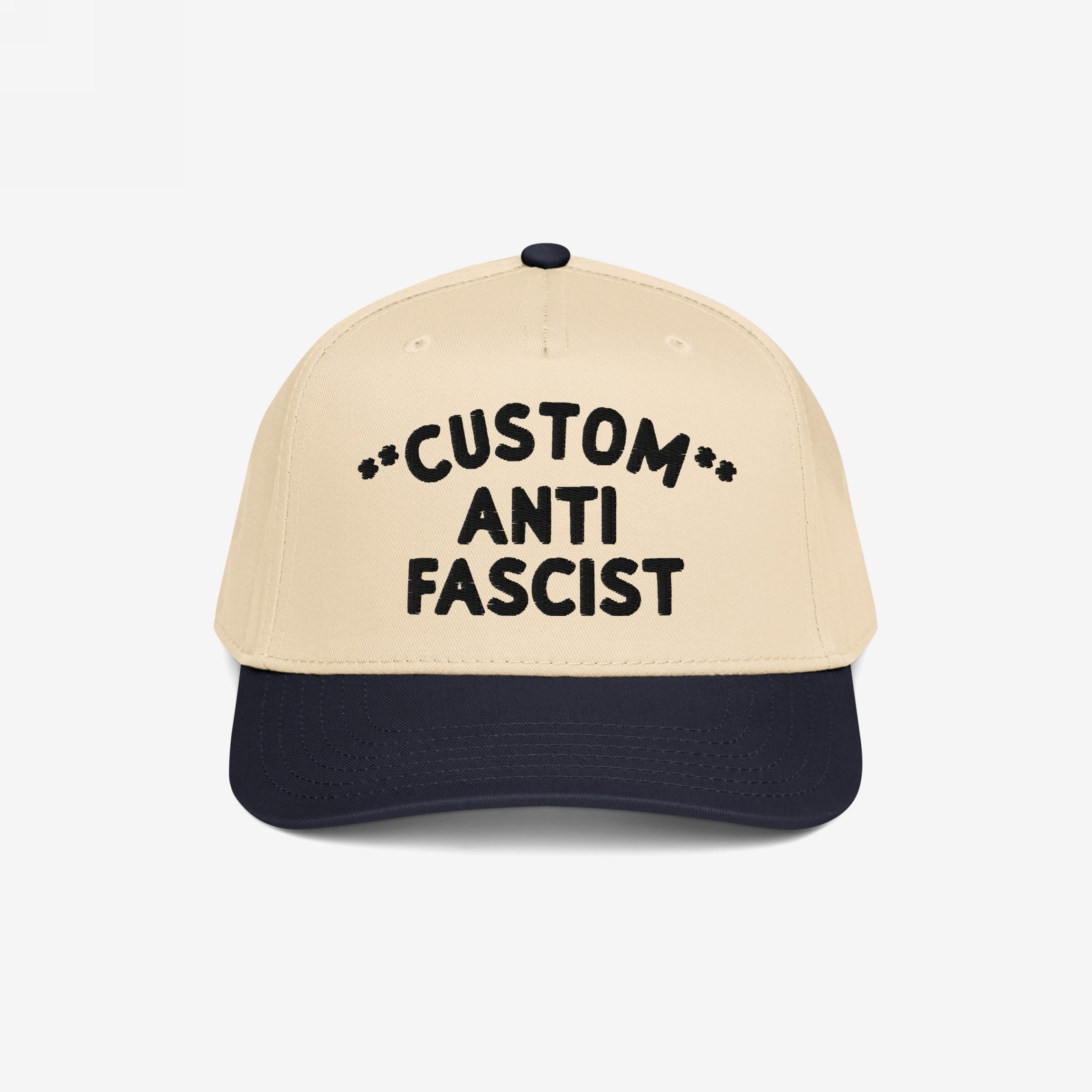 Custom Anti-Fascist 5-Panel Hat with light beige crown and navy bill, featuring bold black embroidered text and decorative asterisks. Designed for personalization and activism, it combines style, comfort, and a powerful message.