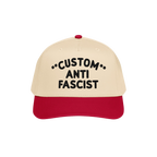Custom Anti-Fascist 5-Panel Hat with beige crown and red bill, featuring bold black CUSTOM ANTI FASCIST embroidery, symbolizi