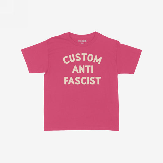 Custom Anti-Fascist Women's Baby Tee featuring bold cream text on a pink background, perfect for expressing personal activism with a customizable touch. Ideal for those who embrace bold, retro-inspired fashion statements.
