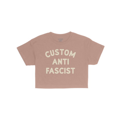 Custom Anti-Fascist Women's Baby Tee featuring bold cream text on a pink background, perfect for expressing personal activism