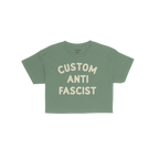 Custom Anti-Fascist Women's Baby Tee features bold cream lettering on a green, short-sleeve crop, promoting activism with a p