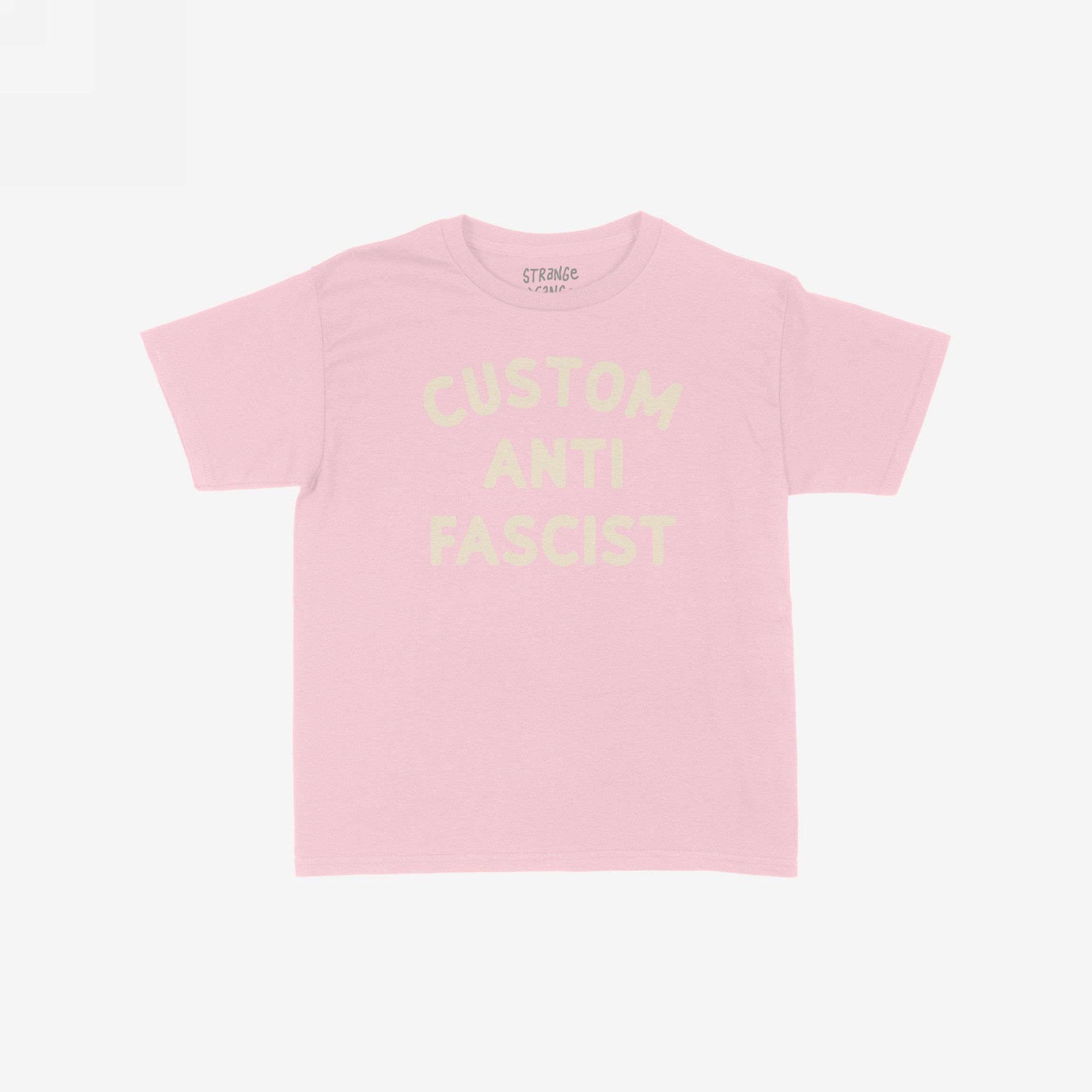 Custom Anti-Fascist Women's Baby Tee, featuring bold block lettering across the chest. This cropped pastel-pink tee combines vintage Y2K style with an activist message, embodying a modern rebel's spirit.
