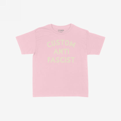 Custom Anti-Fascist Women's Baby Tee, featuring bold block lettering across the chest. This cropped pastel-pink tee combines vintage Y2K style with an activist message, embodying a modern rebel's spirit.