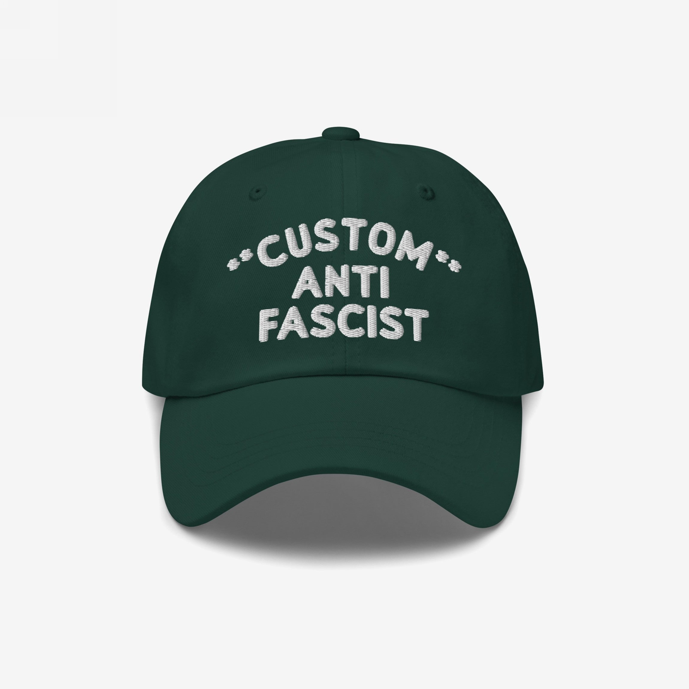 The Custom Anti-Fascist Dad Hat features a dark green design with white embroidery. This unstructured, low-profile cap showcases a bold anti-fascist message, perfect for making a statement.