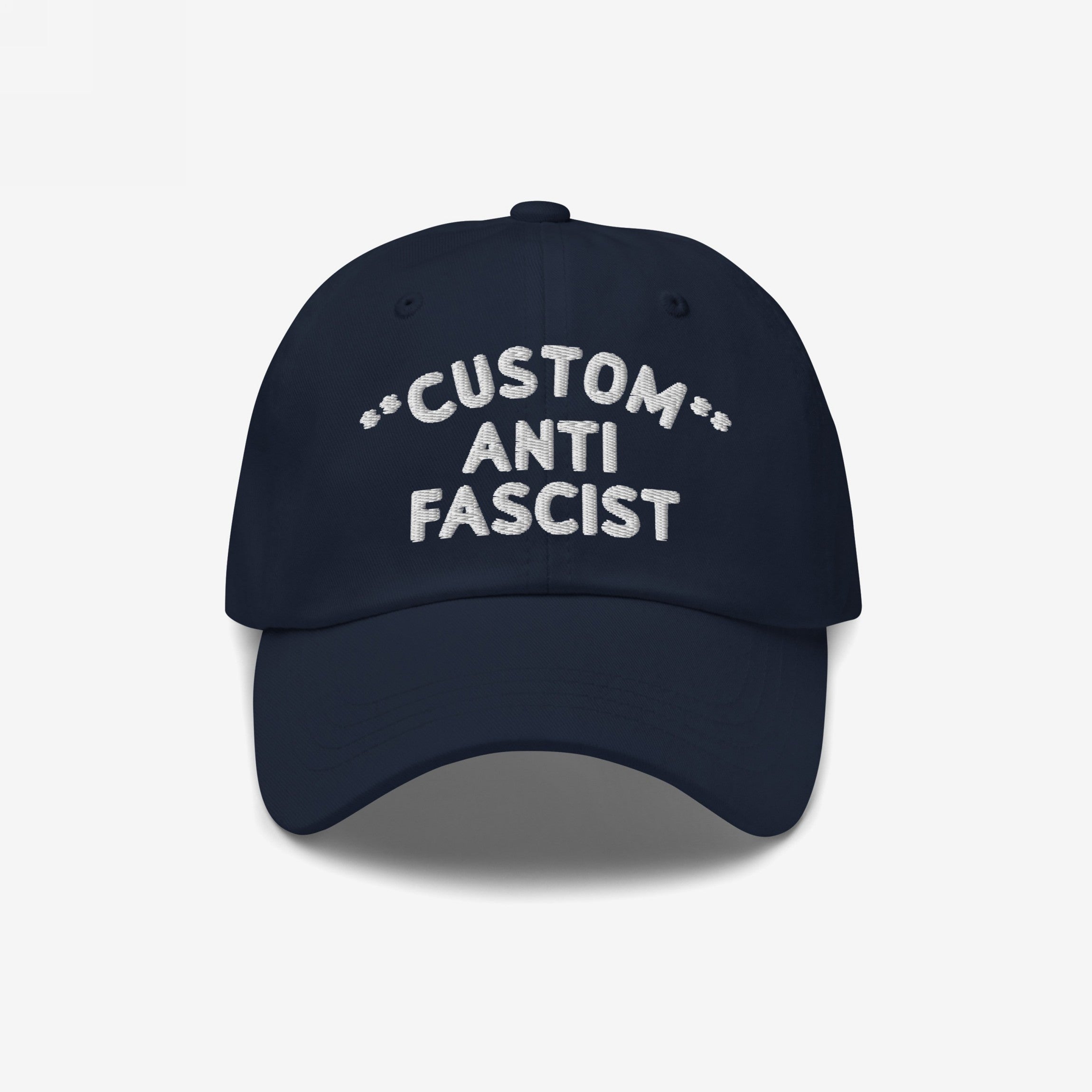 Custom Anti-Fascist Dad Hat featuring a navy-blue design with white embroidered text. This unstructured, low-profile cap has an adjustable back strap and pre-curved visor for personalized, statement-making style.