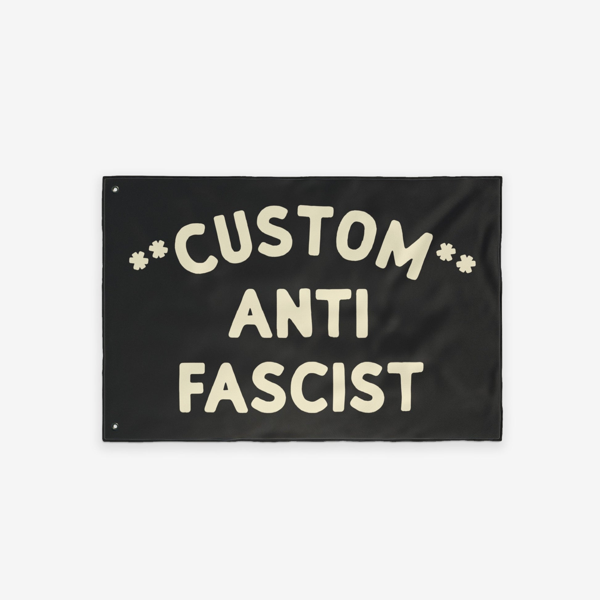 Custom Anti-Fascist Flag featuring bold, cream hand-drawn lettering with Custom arched above ANTI FASCIST and starburst symbols. Includes metal grommets for hanging. Suitable for personalizing with city or message.