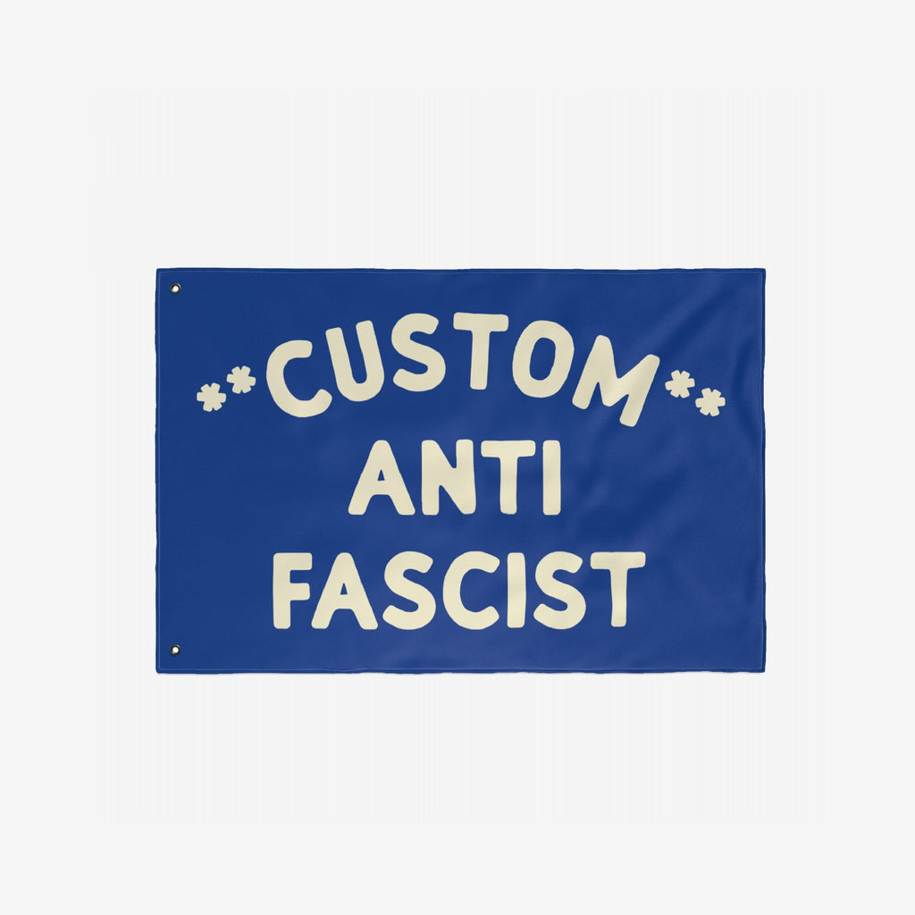 Custom Anti-Fascist Flag featuring bold off-white text on a solid blue background with grommets for hanging. Fully customizable header text, ideal for displaying anti-fascist messages at events or home.