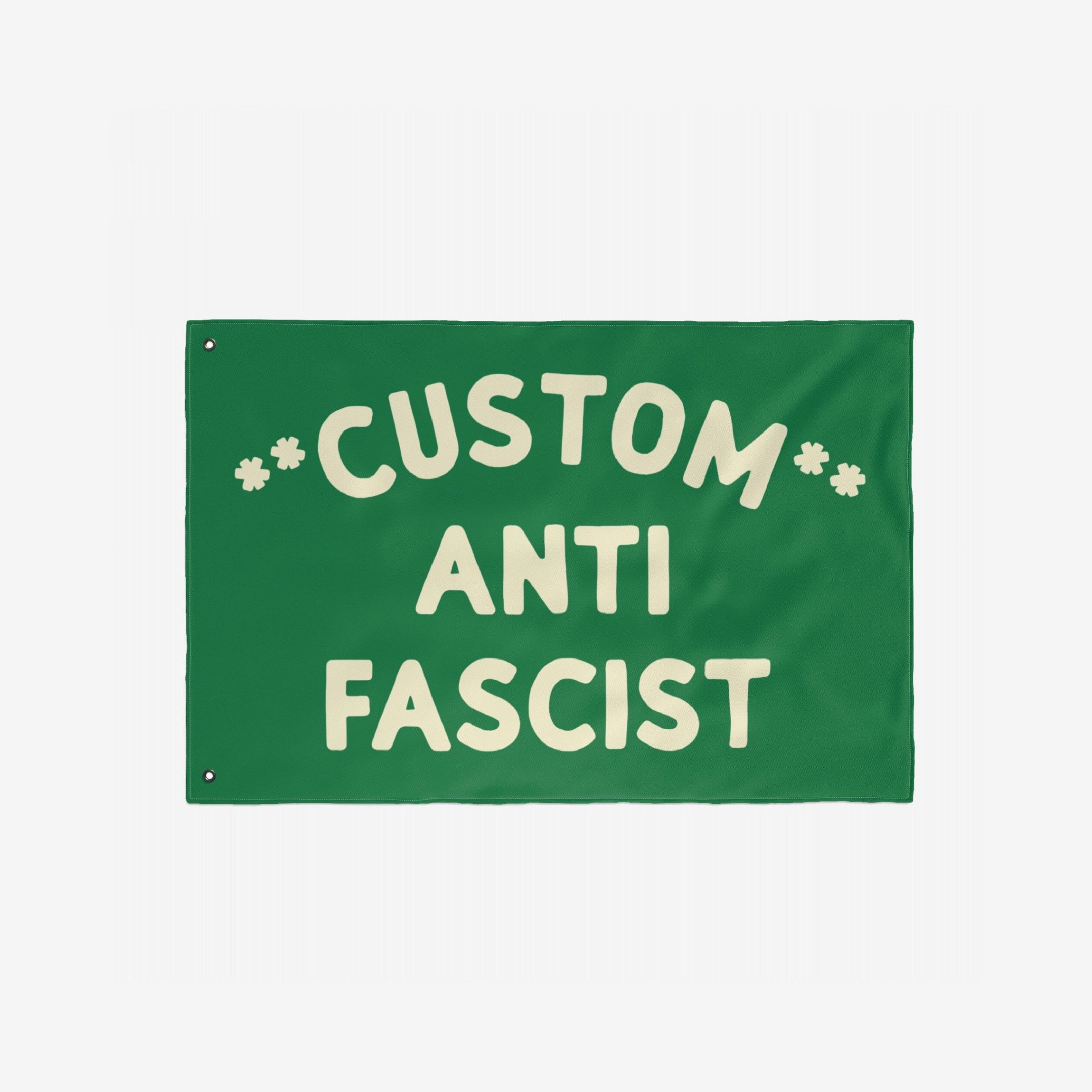 Custom Anti-Fascist Flag featuring bold cream text CUSTOM ANTI FASCIST with two metal grommets. Personalize with your message. Ideal for rallies or home display, promoting equality and anti-hate.