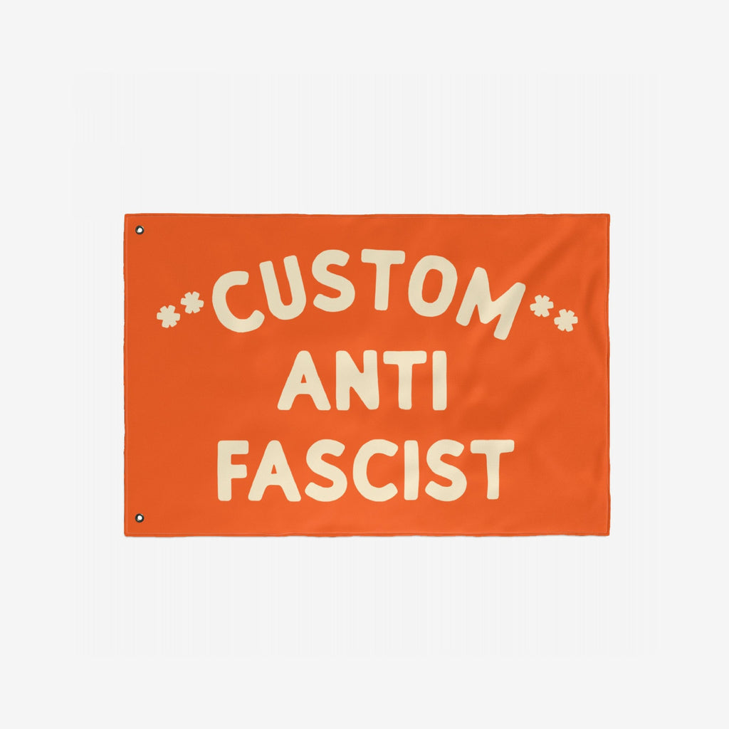Custom Anti-Fascist Flag with bold cream letters, featuring CUSTOM ANTI FASCIST and metal grommets for hanging. Ideal for rallies or events, customizable message replaces CUSTOM for personalized activism.