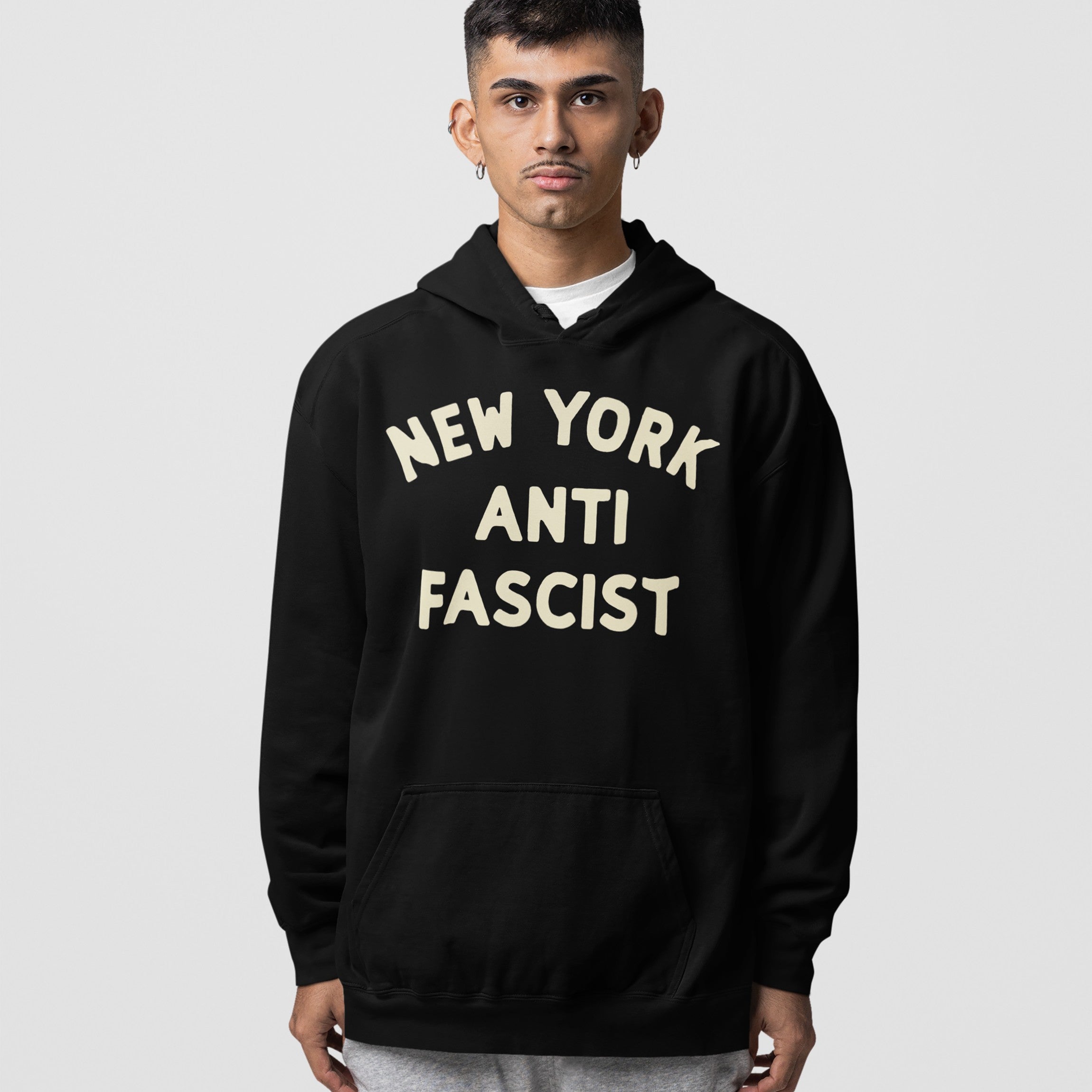 Custom Anti-Fascist Hoodie: A young person models a black hoodie with NEW YORK ANTI FASCIST text in cream, featuring a kangaroo pocket, perfect for making a bold, activist statement.