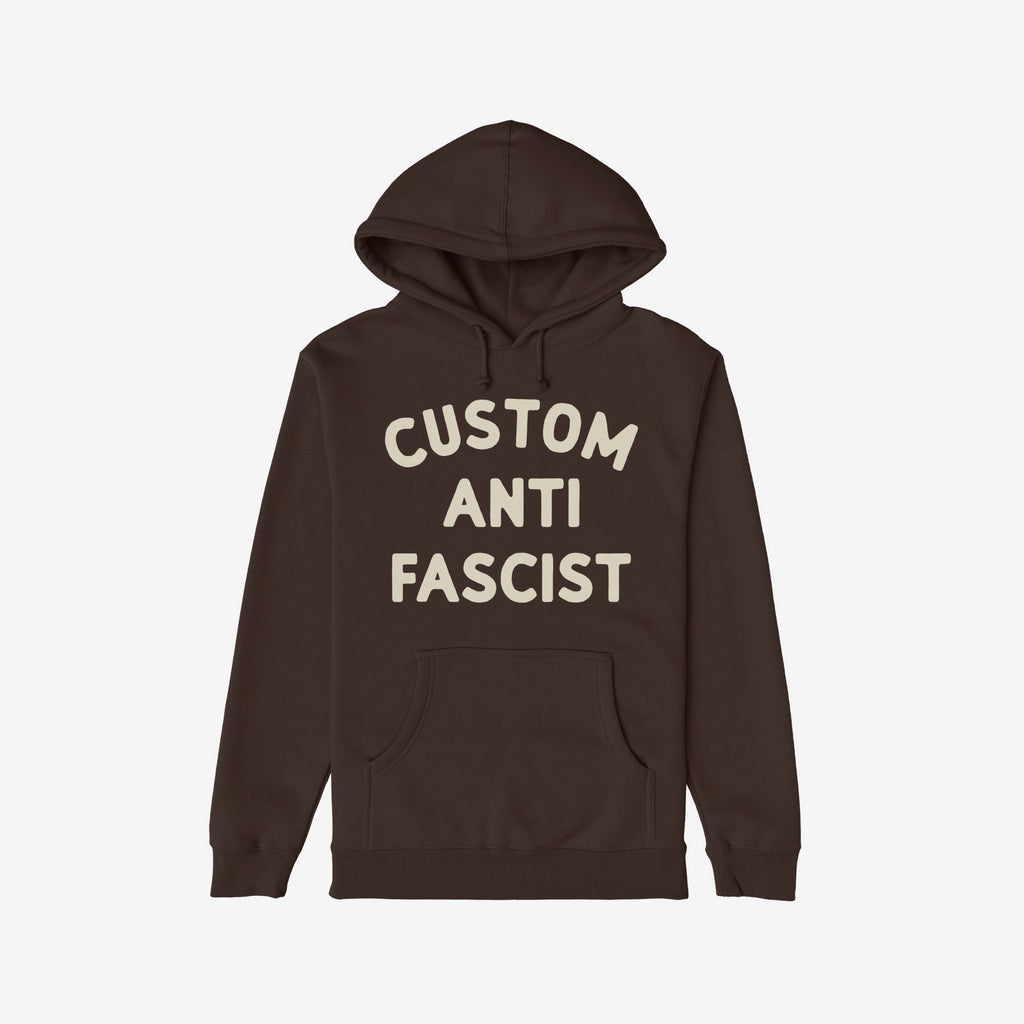 Custom Anti-Fascist Hoodie laid flat, featuring bold off-white text CUSTOM ANTI FASCIST on the chest. Includes a kangaroo pocket and drawstring hood, offering warmth and a statement against fascism.