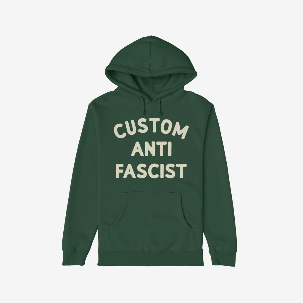 Custom Anti-Fascist Hoodie: Dark green pullover with off-white block letters spelling CUSTOM ANTI FASCIST on the chest. Features kangaroo pocket and drawstring hood. Ideal for expressing values with comfort.
