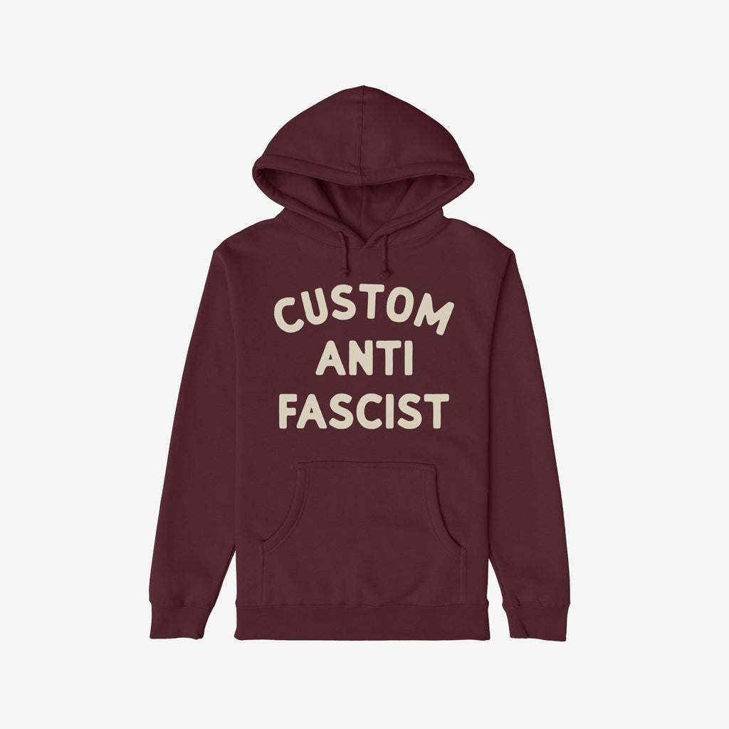 Custom Anti-Fascist Hoodie featuring an off-white Custom Anti Fascist block text on a maroon pullover with a kangaroo pocket and drawstring hood, embodying activism and personal expression.