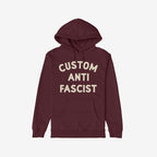Custom Anti-Fascist Hoodie featuring an off-white Custom Anti Fascist block text on a maroon pullover with a kangaroo pocket and drawstring hood, embodying activism and personal expression.
