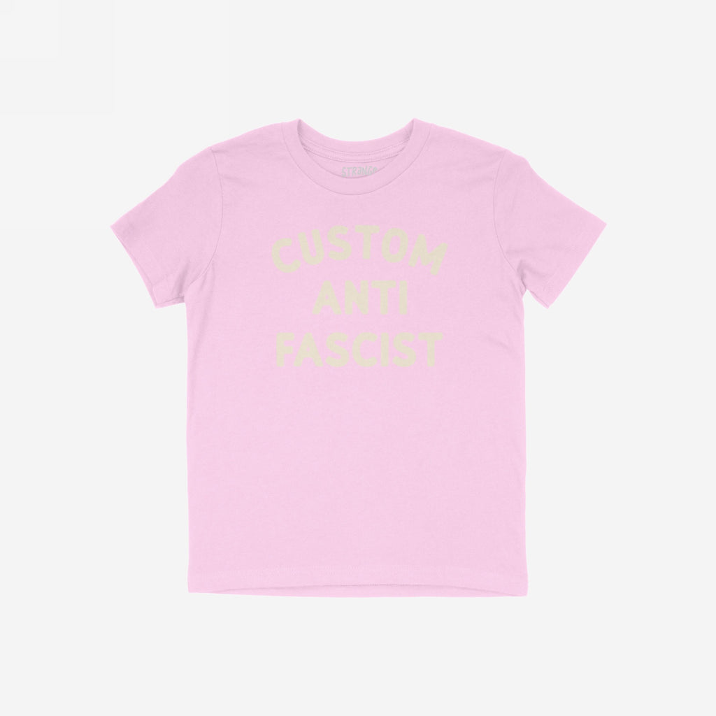 Custom Anti-Fascist Kids T-shirt featuring Custom Anti Fascist in cream ink. The light pink tee is perfect for young activists to express their beliefs in a comfortable, durable style.