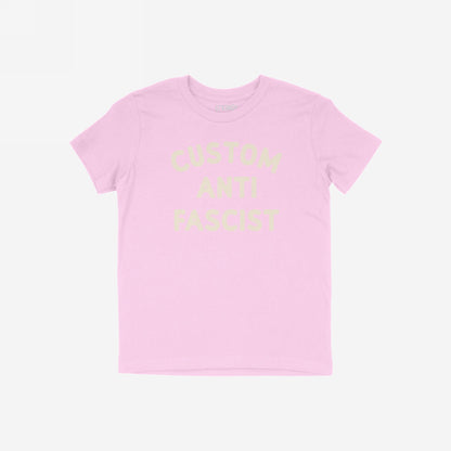 Custom Anti-Fascist Kids T-shirt featuring Custom Anti Fascist in cream ink. The light pink tee is perfect for young activists to express their beliefs in a comfortable, durable style.